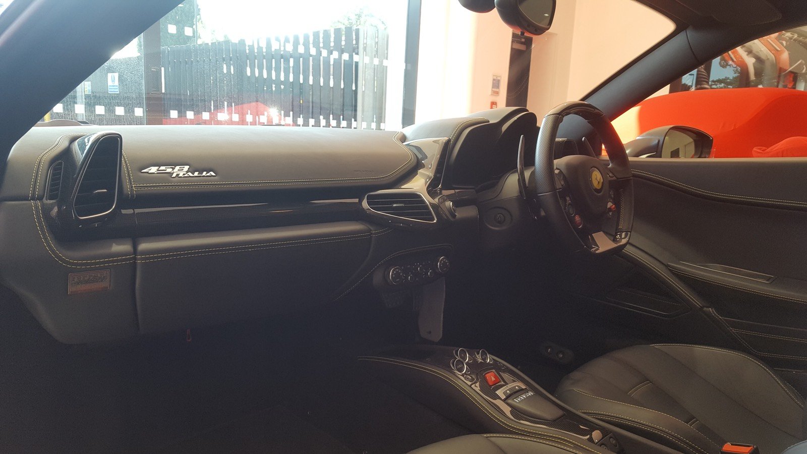 Ferrari 458 Italia cockpit showing its steering wheel, integrated controls, and large paddle shifters