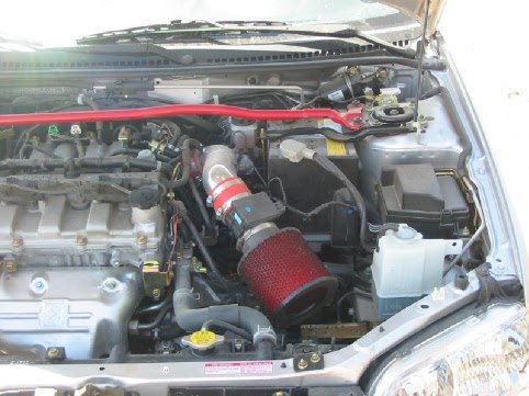 Real photograph of a Mazda engine bay with an aftermarket short-ram intake