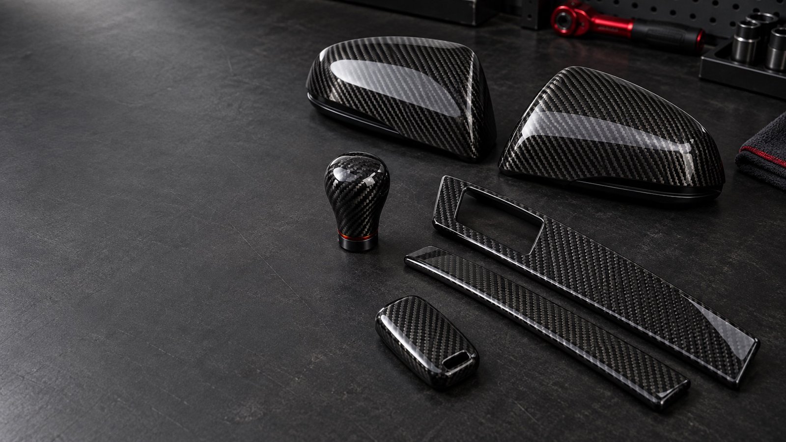 Real carbon fiber car accessories arranged on a premium workshop bench