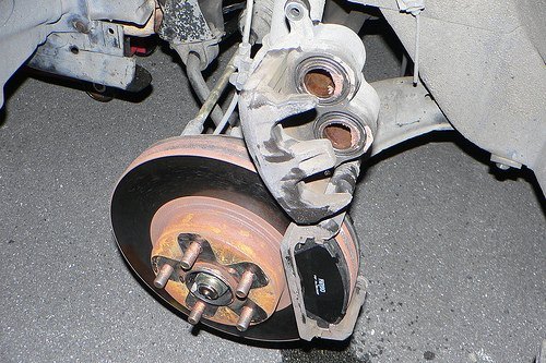 Real photograph of a vehicle brake assembly and wheel mounting studs