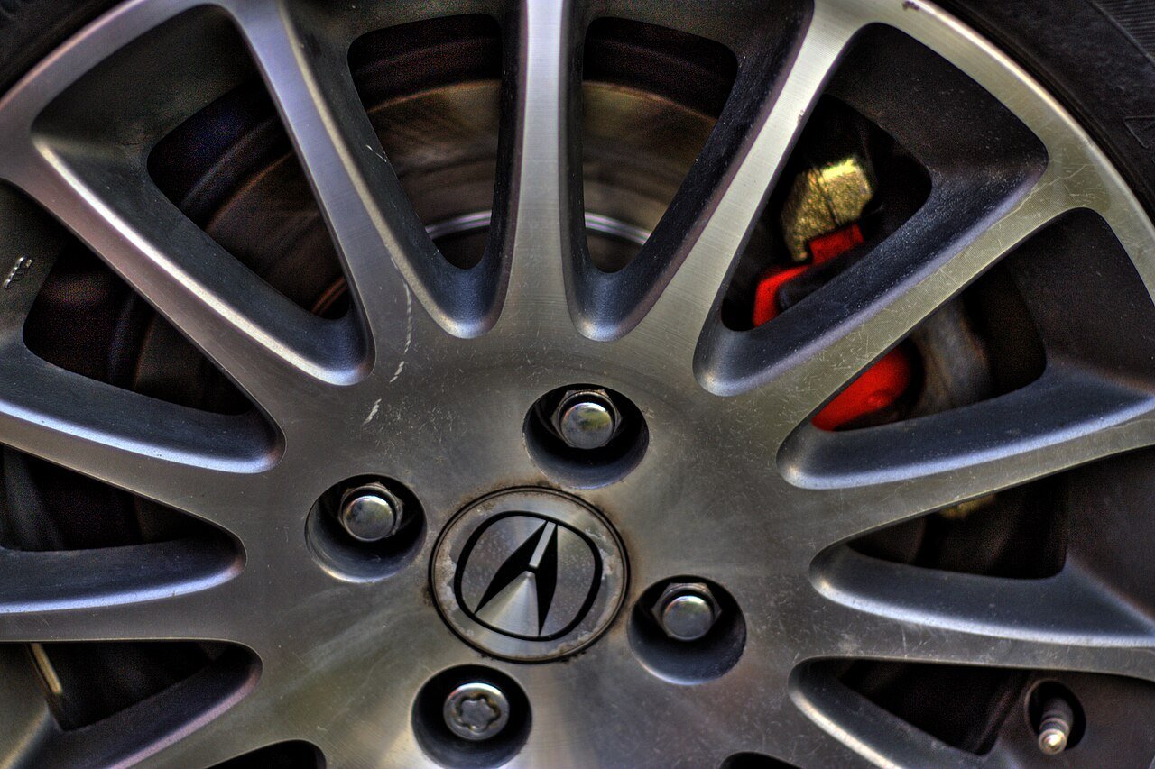 Real close-up photograph of lug nuts installed on an Acura alloy wheel