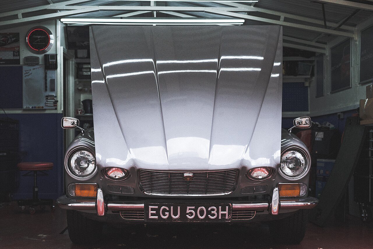Real workshop photograph of a luxury car with its hood open