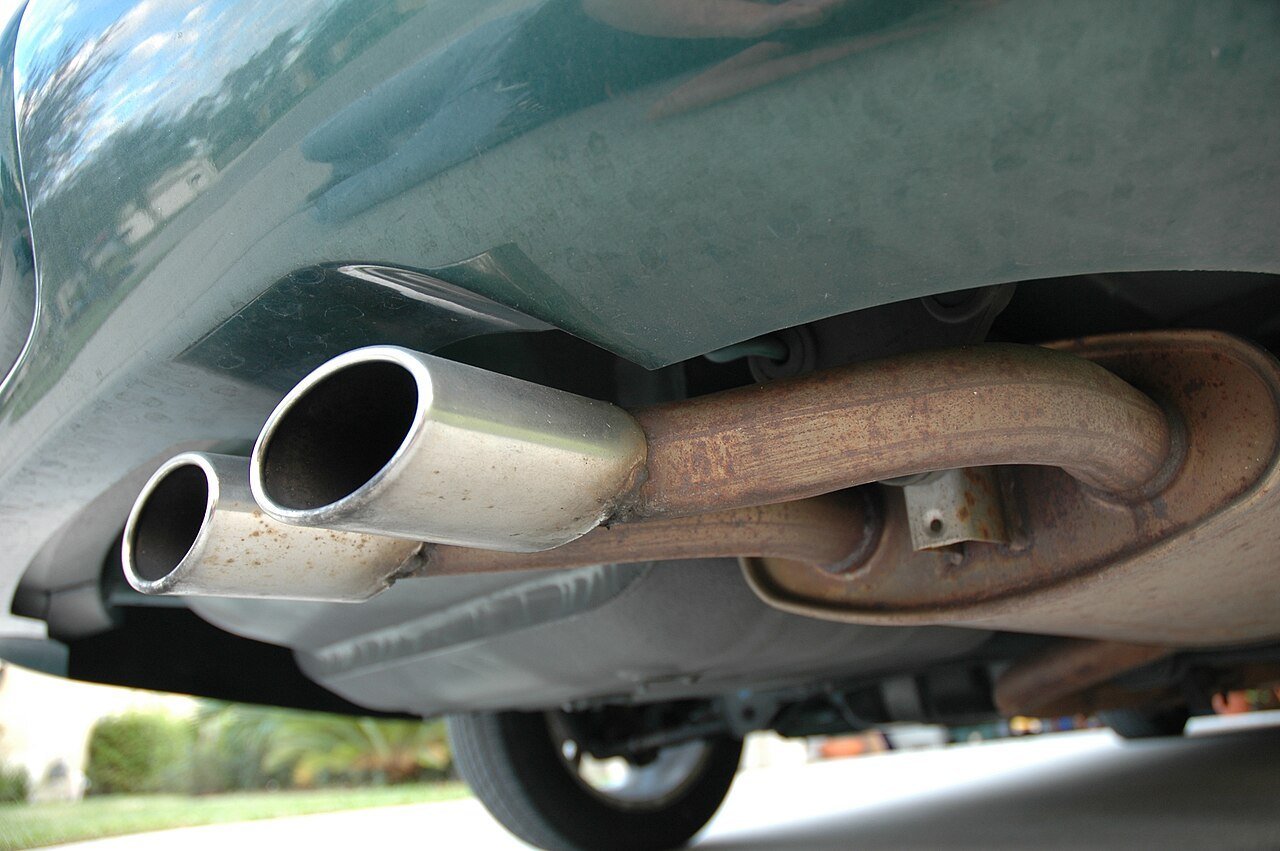 Real photograph of an automotive exhaust muffler and pipe assembly