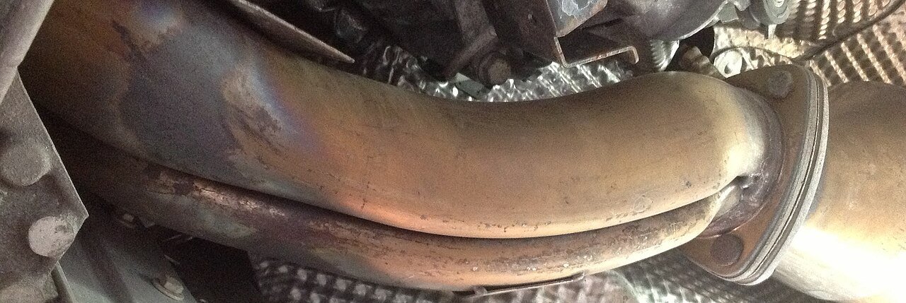 Real photograph of a Y-shaped automotive exhaust pipe section