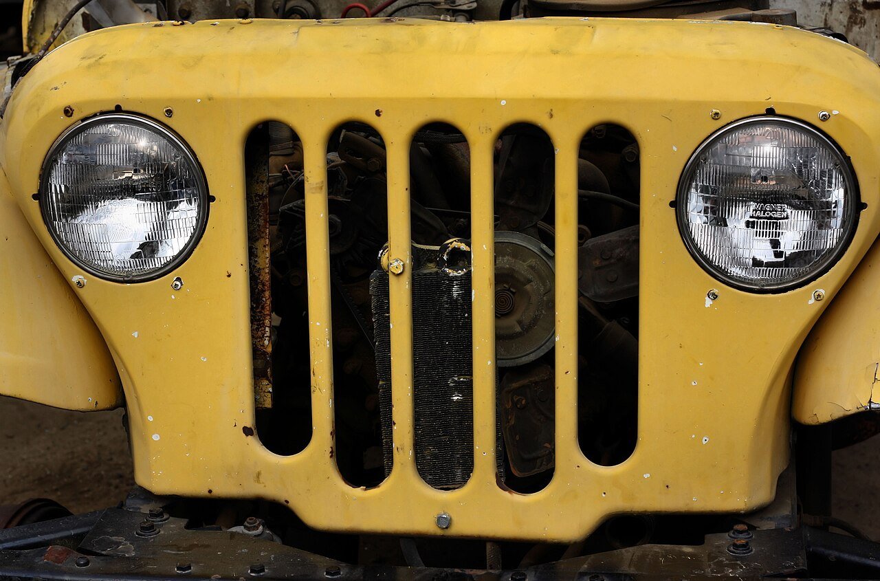 Real close-up photograph of a Jeep grille with vertical slots