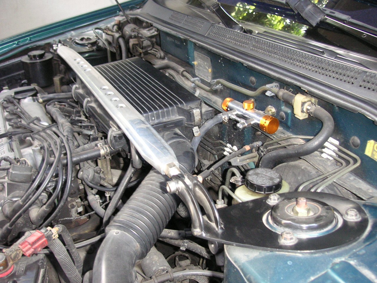 Real photograph of a strut bar installed in a Nissan Sentra engine bay