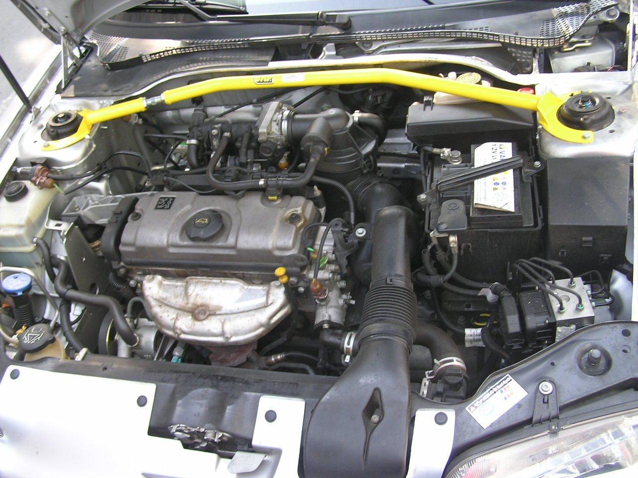 Real photograph of an installed automotive strut brace and tower mount